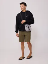 Bandolera negra de nylon con correa ajustable y logo Rusty estampado en blanco.