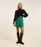 Suéter negro de punto con cuello alto, mangas largas abullonadas y puños largos.