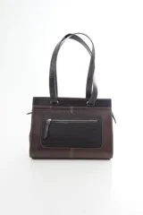 Cartera de cuero marrón de tamaño medio con diseño estructurado, que combina cuero liso y un panel frontal texturizado tipo cocodrilo con bolsillo exterior con cierre. Cuenta con doble asa de hombro y costuras visibles de contraste.