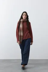 Polera de tejido liviano en color negro, con cuello alto, mangas largas y corte relajado. Presenta un diseño minimalista con recortes laterales que aportan estructura a la prenda.