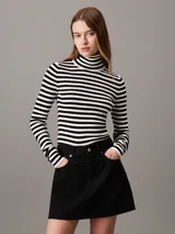 Sweater ajustado de punto a rayas horizontales blancas y negras, con cuello alto y mangas largas.