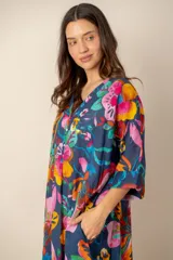 Vestido largo azul marino con estampado floral multicolor, cuello en V con cierre frontal parcial de botones y mangas cortas holgadas.