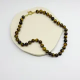 Collar de cuentas esféricas de piedra ojo de tigre de 10 mm, con separadores de nudos de hilo y cierre de mosquetón con baño de oro.
