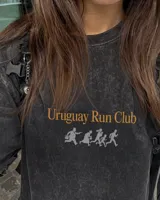 Remera marrón oversize con cuello redondo y mangas cortas. Estampado frontal con el texto "Uruguay Run Club" en celeste y siluetas blancas de personas corriendo.