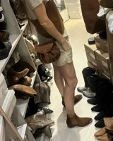 Botín de cuero color marrón, con elásticos laterales, puntera metálica dorada y taco bajo.