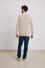 Cardigan azul de tejido de punto con cierre frontal y cuello alto.