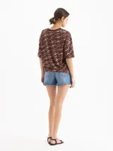 Short de denim azul de tiro medio-alto y silueta relajada, con lavado celeste claro, desgastados suaves y ruedo con acabado al corte.