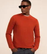Sueter de punto liviano para hombre, de color naranja con textura acanalada horizontal, cuello redondo y mangas largas con puños ajustados.