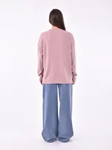 Buzo de punto color marrón claro, de corte holgado y mangas largas.