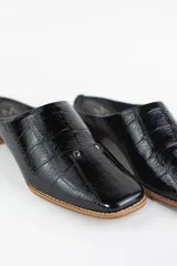 Zueco de cuero con textura tipo croco en color negro, con punta almendrada y taco bajo de madera.