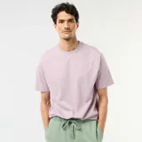Remera de corte oversize color lila, con cuello redondo y mangas cortas de diseño clásico y cómodo.