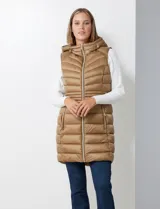 Chaleco largo negro de abrigo, marca Michael Kors. Diseño capitoneado con cierre metálico frontal, bolsillos inclinados y capucha no desmontable con jareta de ajuste. Incluye bolsa autoportante.