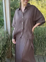 Camisa verde militar de lino italiana con botones de nácar, corte holgado, cuello camisero y mangas cortas con dobladillo.