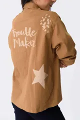 Campera verde militar de algodón con mangas largas y cuello camisero. Estampado en la espalda con la frase "Trouble Maker" y una estrella.
