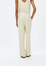 Pantalón recto de tiro alto color marrón, con pinzas delanteras, trabillas para cinturón y cierre frontal oculto.