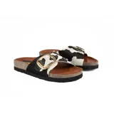 Sandalias bajas con base de corcho y tira ancha de pelo con estampado de vaca y hebilla dorada.