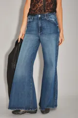 Jean de corte palazzo con tiro alto y pierna ancha, confeccionado en denim de lavado azul oscuro con efecto desgastado.