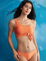 Top de bikini color naranja, estilo bandeau asimétrico con un solo tirante en el hombro y un lazo decorativo en el centro del busto.