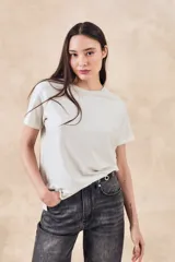 Remera de manga corta, corte oversize, color beige claro con brillo sutil.