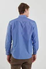 Camisa celeste con micro estampado, de corte clásico, manga larga y cuello abotonado.