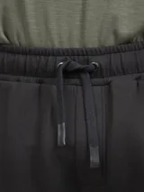 Pantalón de jogging negro con cintura elástica y cordón de ajuste, de corte entallado y puños acanalados en los tobillos.