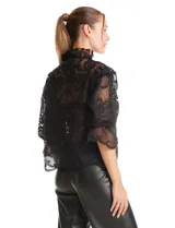 Blusa de tul bordado color negro, con cuello alto, cierre frontal con botones y mangas tres cuartos con terminación amplia.