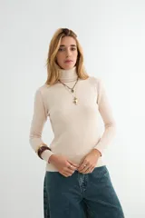 Polera de cuello alto y manga larga, confeccionada en tejido de punto fino con puños y ruedo acanalados.