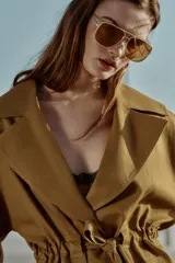 Chaqueta estilo trench corta color azul marino confeccionada con lino. Cuenta con cuello solapa, manga larga con trabilla, bolsillos delanteros de vivo y cierre frontal con lazada ajustable en la cintura.