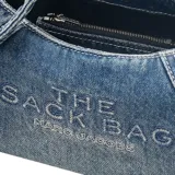 Bolso Marc Jacobs modelo The Bow Denim Mini Sack, confeccionado en denim azul con lazo decorativo extragrande. Cuenta con asa superior y correa cruzada ajustable de cuero.