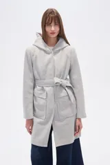 Tapado de manga larga con capucha y bolsillos frontales con solapa, confeccionado en color gris claro. Presenta un diseño holgado con un lazo ajustable en la cintura del mismo material.