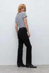 Pantalón de corte recto en color negro, con cierre frontal y bolsillos laterales. Diseño clásico de tiro medio.