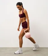 Short deportivo de corte runner con cintura elástica ancha y bajo redondeado. Presenta un diseño holgado y funcional, ideal para actividades físicas.