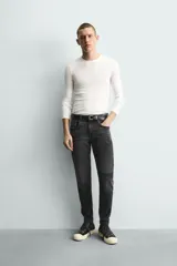 Jeans skinny fit de corte ajustado y tiro medio en color negro con efecto lavado y detalles desgastados. Confeccionados en tejido elástico con mezcla de algodón, presentan diseño clásico de cinco bolsillos y cierre frontal con cremallera y botón.