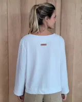 Remera de manga larga color marrón chocolate, con cuello redondo y dos bolsillos frontales tipo parche.