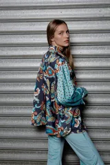 Camisa holgada estampada con motivos paisley en tonos marrón, beige y azul. Tiene cuello solapa, mangas largas y cierre frontal con botones.