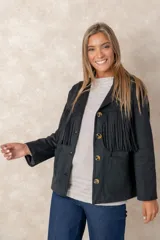 Chaqueta de gamuza sintética color marrón, con diseño de flecos en el pecho y la espalda. Presenta cierre frontal con botones, cuello camisero y bolsillos cuadrados frontales.