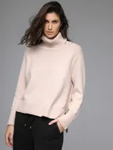 Sweater color beige de tejido de punto, con cuello alto y corte asimétrico.