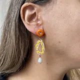 Aros colgantes con pasador naranja, pieza transparente con diseño amarillo y perla de río.