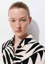 Vestido midi de viscosa con estampado de hojas en blanco y negro, sin mangas, con cuello camisero, cierre frontal de botones y cinturón a juego.