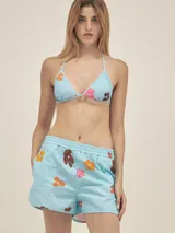 Short de tejido seersucker celeste con estampado de flores pixeladas en tonos marrón, naranja y rosado. Posee cintura elástica y bolsillos laterales.
