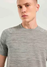Camiseta deportiva de manga corta con cuello redondo, confeccionada en tejido técnico con textura jaspeada y detalle de logo pequeño en el ruedo.