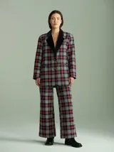 Pantalón de tiro alto con corte ancho y recto, confeccionado en tela de algodón con estampado de cuadros escoceses en tonos azul marino, verde y rojo. Presenta cierre frontal oculto con botones internos y pasacintos en la cintura.