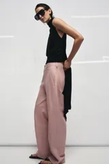 Pantalón de tiro medio confeccionado en piel 100%, con diseño de corte recto y costuras horizontales marcadas. Presenta cintura con trabillas, bolsillos laterales y cierre frontal con cremallera y botón.