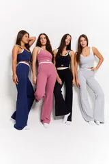 Conjunto deportivo de dos piezas en color gris, compuesto por un top corto sin mangas con cuello redondo y logo estampado en el frente, y un pantalón de corte recto y tiro alto con cordón ajustable en la cintura.