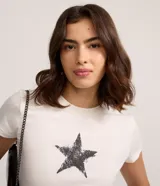 Remera de manga corta y cuello redondo, color blanco crudo, con un estampado central de estrella de cinco puntas con efecto desgastado o grunge.