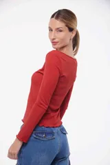 Remera de mangas largas color celeste, con cuello redondo y terminaciones con volados.