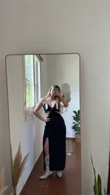 Vestido largo negro de lino con breteles finos de ecocuero plateado, escote en V con abertura circular y tajo lateral.