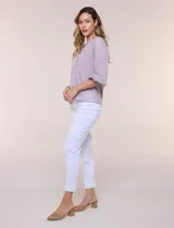 Blusa de gasa de color lila con calce holgado, cuello a la base con escote en V y cartera de botones a tono. Cuenta con fruncidos en el cuello y hombros que otorgan volumen, manga tres cuartos estilo abullonado con puño elastizado y ruedo suavemente redondeado.