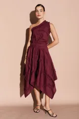 Falda midi asimétrica color bordó, con volados decorativos en espiral y cierre lateral.