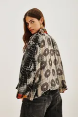 Kimono de viscosa con diseño estampado de círculos y efecto tie-dye, con bordes frontales decorados con aplicaciones bordadas y pedrería multicolor.